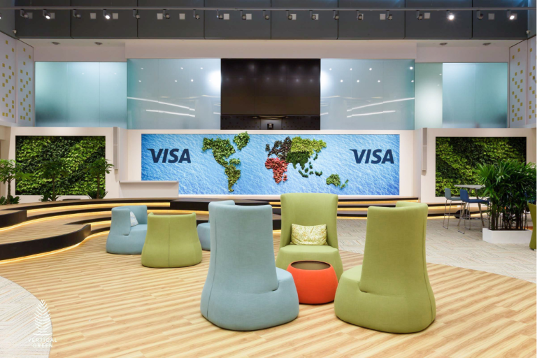 Modern corporate reception featuring a full-height living green wall, contemporary lounge seating, timber ceiling details and a bright office corridor.
